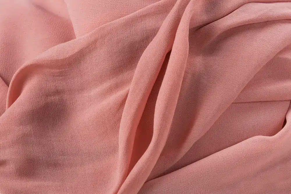 Soft pink velvet fabric texture representing comfort.